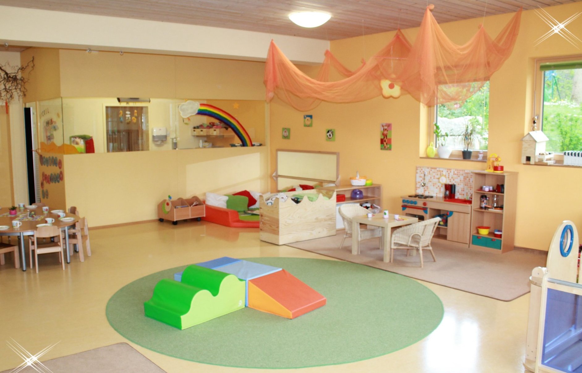 Kindergarten Innenraum mit Spielzeugen an den Wänden und auf dem Boden. Auf dem Bild sind keine Kinder zu sehen.