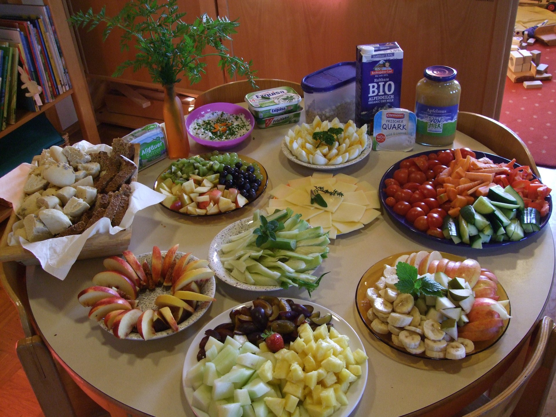 Vollgedeckter und schön angerichteter Tisch mit Gemüse, Obst, Käse und Wurst.